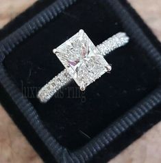 a diamond ring sitting on top of a velvet box