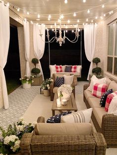 an outdoor living area with couches, chairs and lights hanging from the ceiling above