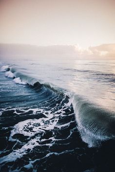 the ocean waves are crashing on the beach