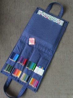 a blue bag filled with lots of colored pencils