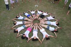 a group of people standing in the middle of a circle on top of green grass