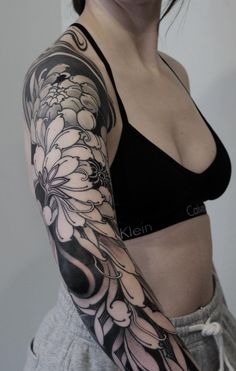 a woman with a black and white tattoo on her arm