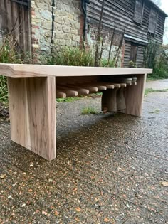 a wooden bench sitting on top of a gravel road