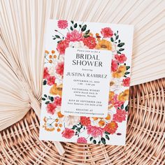 the floral bridal shower is on top of a wicker basket next to a fan