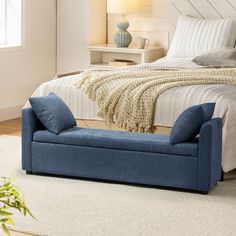 a blue bench sitting in front of a bed on top of a white carpeted floor