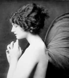 an old photo of a woman with a butterfly on her back