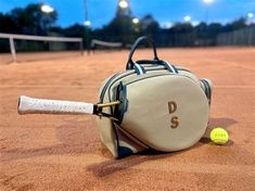 a tennis racket and ball laying on the ground