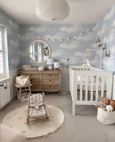 a baby's room with a crib, dresser and rocking chair in it