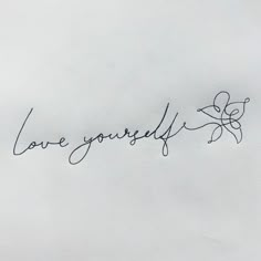 the word love yourself written in cursive writing on a piece of white paper