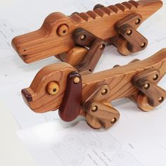 two wooden toy alligators sitting on top of paper