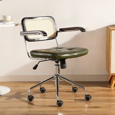 a green office chair sitting on top of a hard wood floor