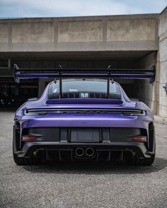 a purple sports car parked in front of a garage