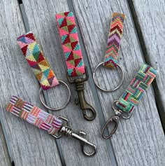 four key fobs with different patterns on them sitting on a wooden table next to each other