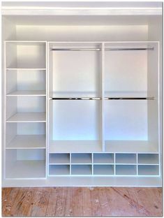 an empty closet with white shelves and drawers on the wall, in front of a wooden floor