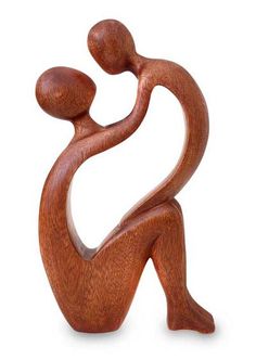 a wooden sculpture of a person holding a child