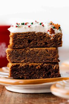 three pieces of cake on a plate with frosting and sprinkles