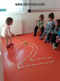 children are sitting on chairs and playing with wooden sticks