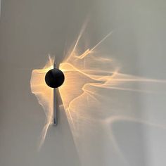 a wall light that is on the side of a wall with some lights coming from it