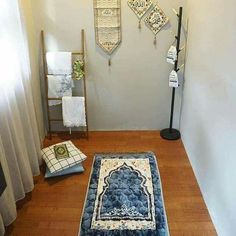 a hallway with wooden floors and rugs on the floor next to a wall mounted coat rack