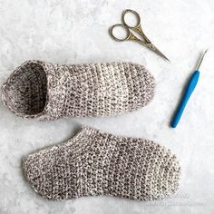 a pair of crocheted slippers next to a pair of scissors