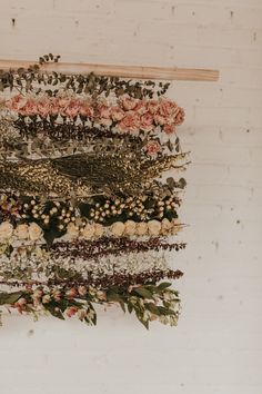 an arrangement of flowers hanging on a wall