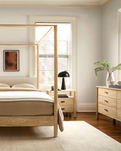 a bedroom with white walls and wooden furniture