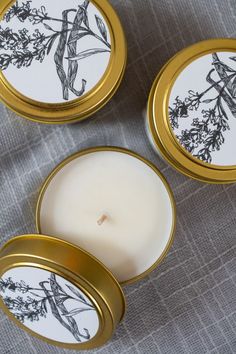 three small candles sitting on top of a table next to each other with designs on them