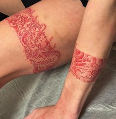 a woman's legs with red tattoos on them