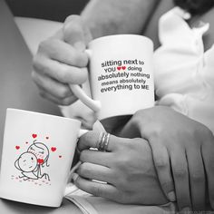 two people holding coffee mugs with writing on them