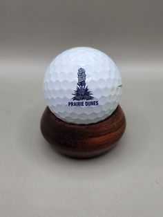 a white golf ball sitting on top of a wooden stand