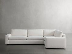 a white couch sitting on top of a gray floor