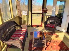 two wicker chairs sitting on a porch