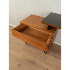 a wooden table with two drawers on wheels and one drawer open to show the bottom