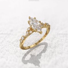 a pear shaped diamond ring on top of snow