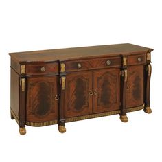 a large wooden sideboard with gold trimmings