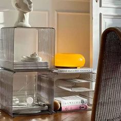 a stack of books sitting on top of a wooden floor next to a chair and table