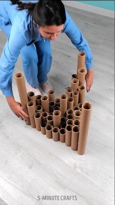 a woman kneeling on the floor with rolls of toilet paper in front of her