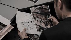 a man looking at pictures on top of a table