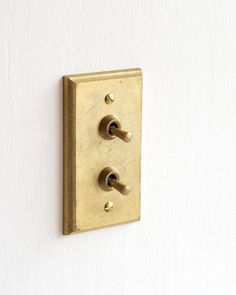 a wall mounted light switch with two knobs on it's side and one button in the middle