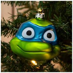 an ornament shaped like a turtle hanging from a christmas tree with eyes drawn on it