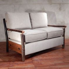 a couch sitting on top of a hard wood floor next to a wall with a wooden frame