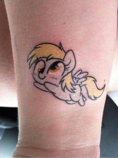 a small cartoon character tattoo on the arm