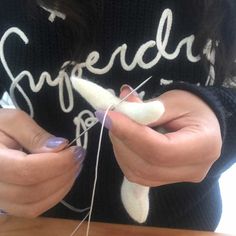 a woman is working on some type of crafting project with yarn and scissors in her hands