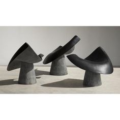 three black sculptures sitting on top of cement bases