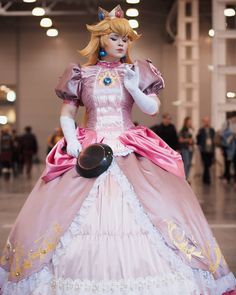 a woman in a pink and white dress is dressed up