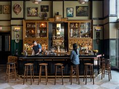 two people sitting at a bar in a restaurant