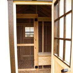 an open door to a small chicken coop