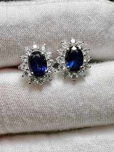 Natural Blue Sapphire & White Sapphire Halo 925 Sterling Silver Stud Earrings  natural oval blue sapphires (7.1mm x 5mm) natural white sapphire halos Total Measurement including halo: 11.5mm x 9.3mm Blue Bridal Earrings, Blue Sapphire Earrings, Sapphire Stud Earrings, Blue Sapphire Studs, Sapphire And Diamond Earrings, Halo Stud Earrings, Sapphire Earrings Studs, Sapphire Studs, Halo Earrings Studs