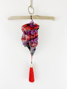 a red and purple scarf hanging from a hook