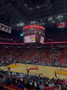 an indoor basketball game in progress with the crowd on the sidelines and fans watching